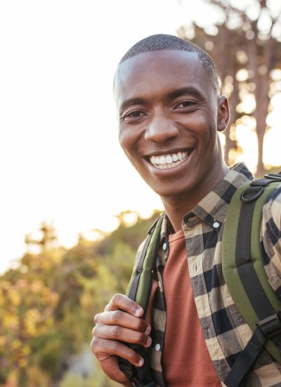 Smiling,Young,African,Man,In,A,Backpack,Taking,Selfies,While